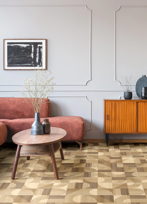 A pink sofa with retro wooden style furnishing. Patterned geometric wood effect vinyl flooring.